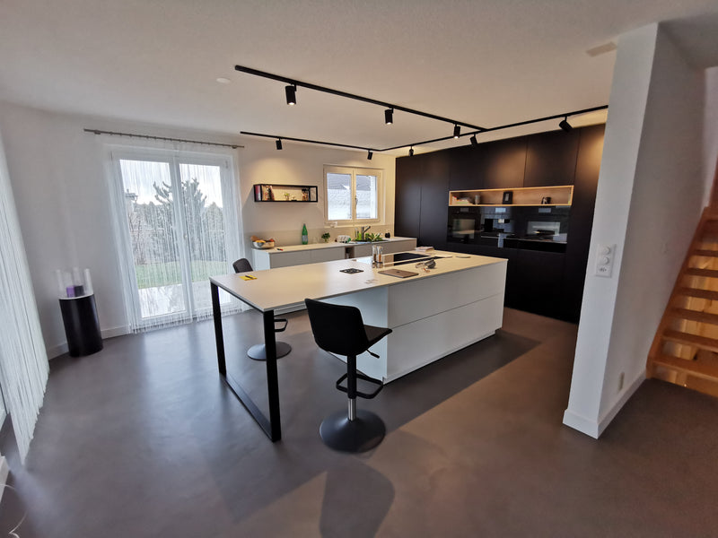 Photo après rénovation d’une cuisine avec sol en béton époxy Micropox, offrant un design épuré et une finition haut de gamme.